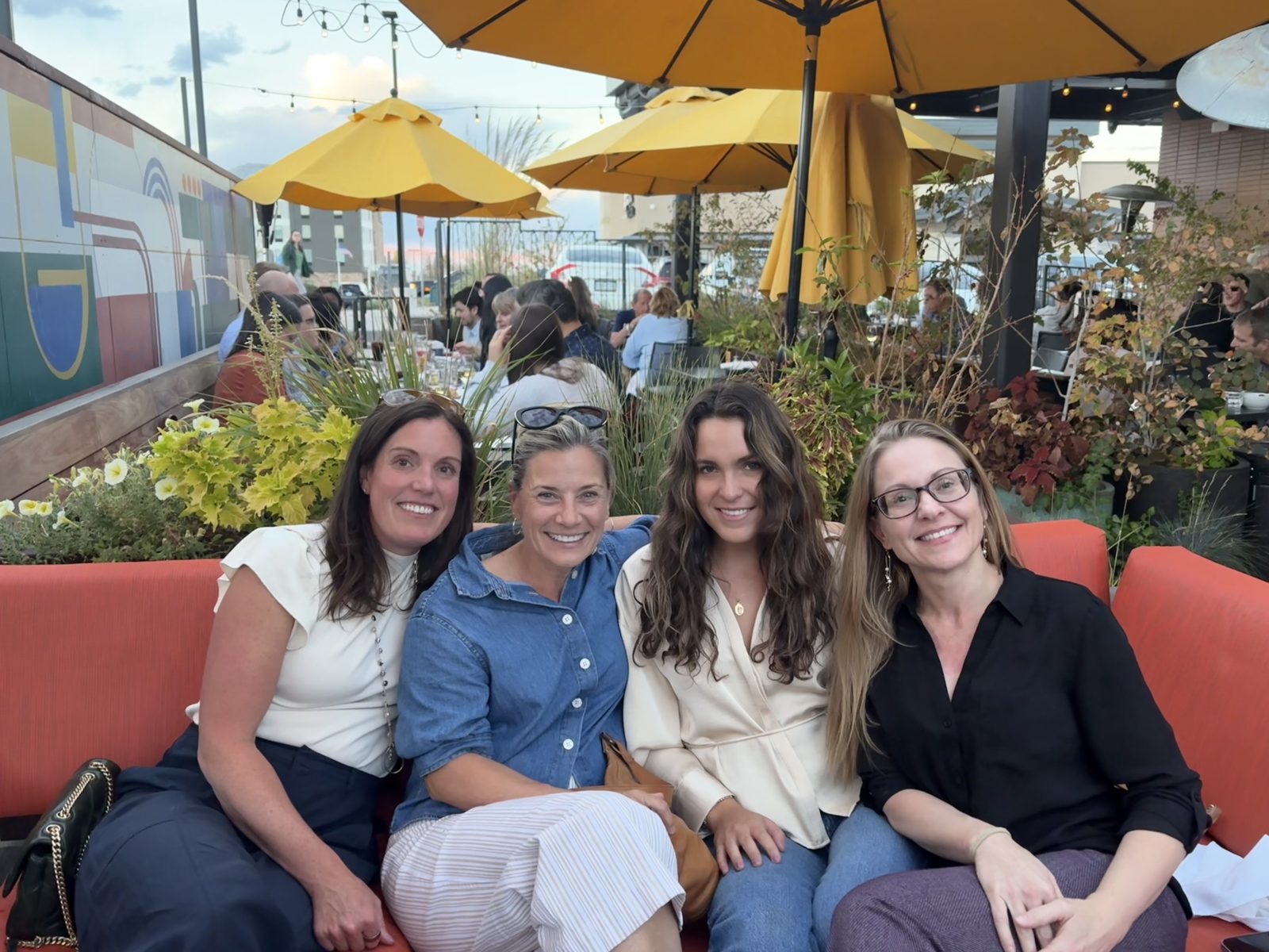 Olivia with friends on a sunny restaurant patio